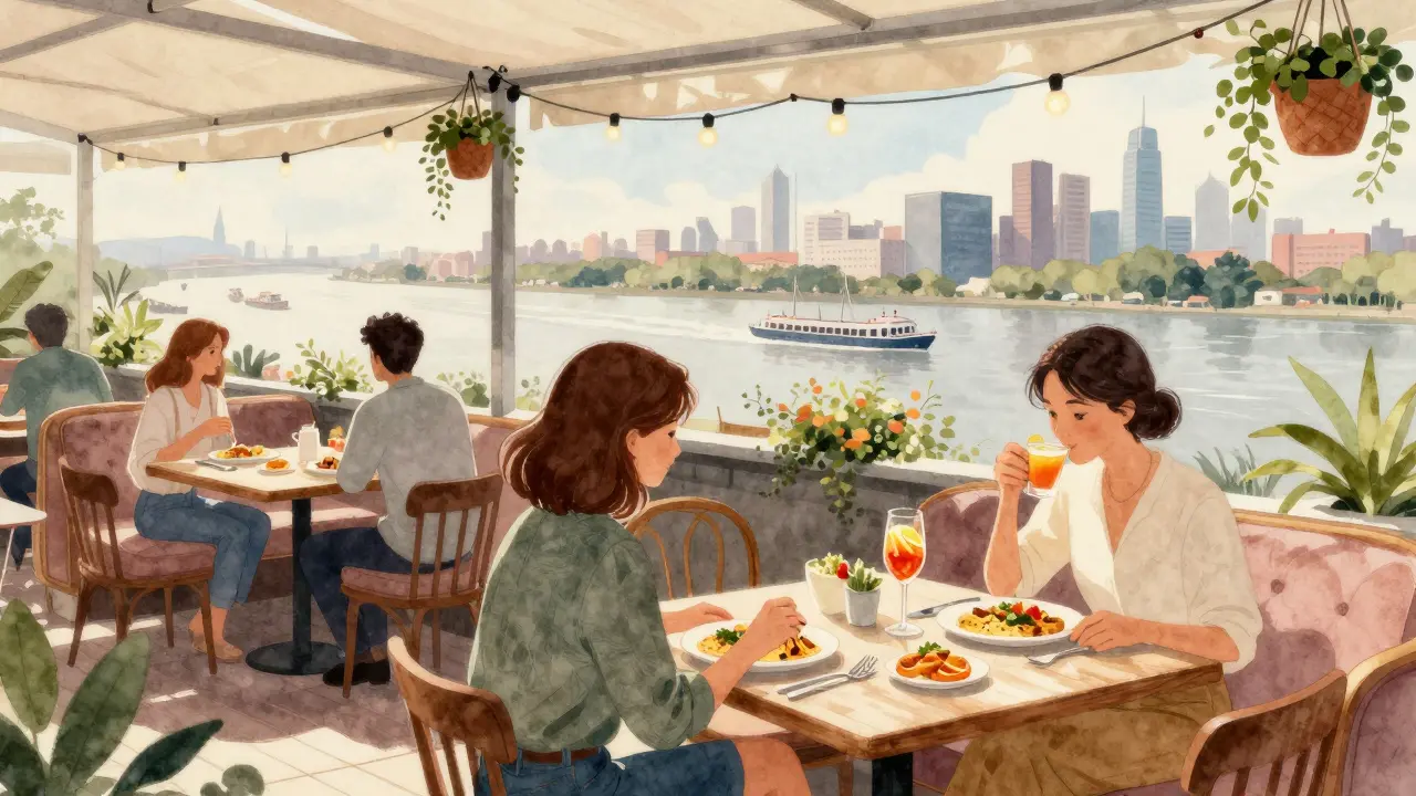 Cozy terrace with river views, guests sipping mimosas and eating vegan dishes among greenery.